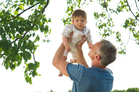 Father playing with his son. Dad keeps his son in  arms.