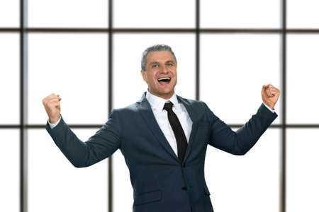 Mature businessman laughing happily. Joyful boss on white background. Politician celebrating his victory. Nothing can stop me.の写真素材