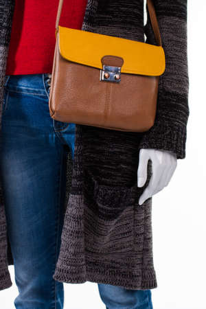 Blue jeans with bicolor handbag. Mannequin wearing purse and jeans. Girl's fashionable apparel with accessory. Good choice of autumn clothes.の写真素材