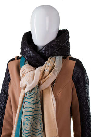 Tied scarf over hooded jacket. Female mannequin wearing stylish scarf. Quilted hood and trendy scarf. Autumn discounts in outlet shop.の写真素材