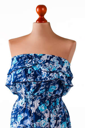 Sleeveless blue floral dress. Sleeveless dress on beige mannequin. Woman's stylish floral pattern...