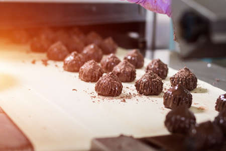 Brown sweets on beige cloth. Dark candies with shavings. Dream of a gourmet. Special recipe of savoury dessert.の写真素材