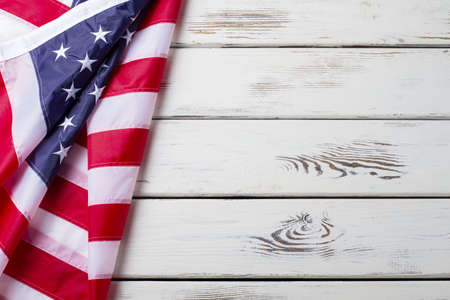 Crumpled US flag. US flag on wooden background. National banner on white floor. Unity and pride.の写真素材