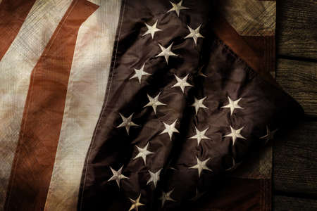 Aged and crumpled US flag. Old flag on wooden background. Courage, honor and loyalty. Fallen shall...
