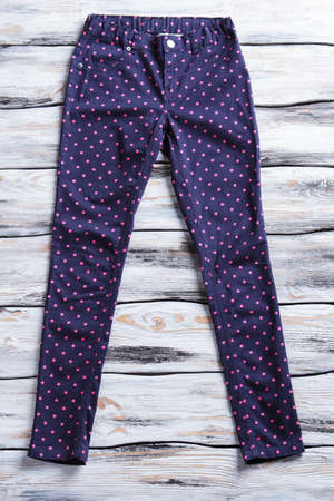 Dotted navy pants. Dark trousers on wooden background. Quality cotton pants for girls. Stylish design of clothing.の写真素材
