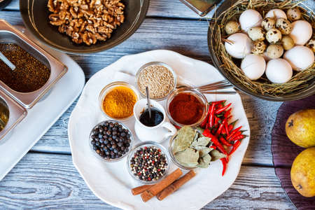Pepper and bowl of eggs. Plate with spices beside walnuts.の写真素材