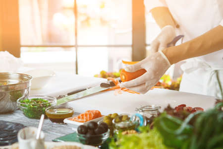 Hands with knife cut carrot.の写真素材