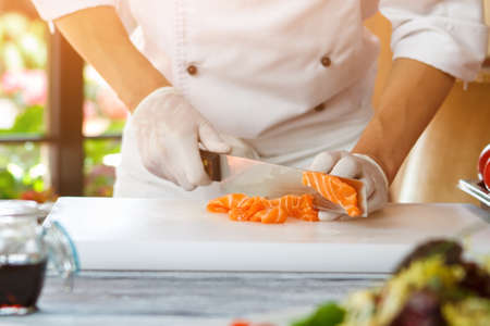 Hand with knife cutting fish.の写真素材