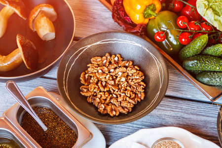 Bowl of walnuts beside mushrooms.の写真素材
