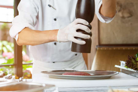 Man's hands with pepper dispenser.の写真素材