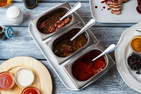 Liquid with pieces of meat. Bowls with spices and sauce. Aromas and flavors. Tomato ketchup and juicy veal.の写真素材