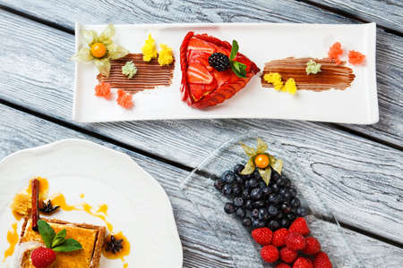 Cake and berries on plates. Blueberry and raspberry. European desserts on restaurant table. Honey...