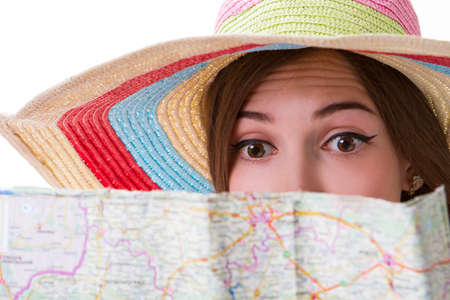Woman's face behind a map. Surprised lady looks at map. Where is the nearest river. Travelling around the country.の写真素材