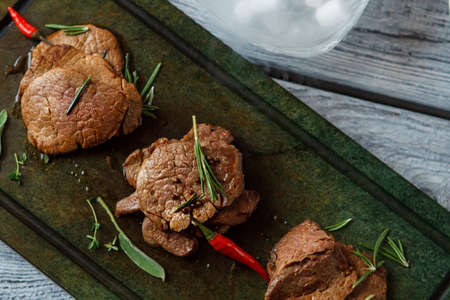 Cooked meat on a tray. Meat with chili pepper. Delicious veal medallions. Incredible taste of european cuisine.の写真素材