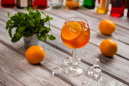 Wineglass with orange cocktail with Mint in small bucket.の写真素材