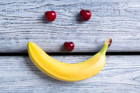Smiley face made of fruits, Banana and cherries.の写真素材