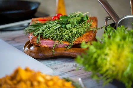 Green herbs and meat. Meat piece on wooden board. Beef with rosemary and thyme. Simple and tasty dish.の写真素材