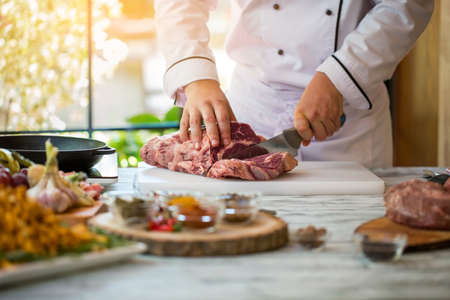 Man is cutting meat. Hand with kitchen knife. Tenderloin for delicious steak. What to cook from beef.の写真素材
