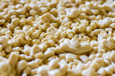 Lots of dough pieces. Raw pastry of light color. Prepare decoration for wedding bread. Heat up the oven.の写真素材