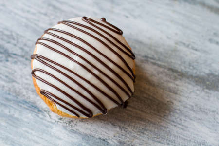 Biscuit with white icing. Cookie on gray wooden background. Decorated bush cake. Top view of fresh...