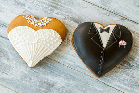 Wedding cookies on gray background. Biscuit shaped as tuxedo. Sweet treats for loving hearts. Best regards to newlyweds.の写真素材