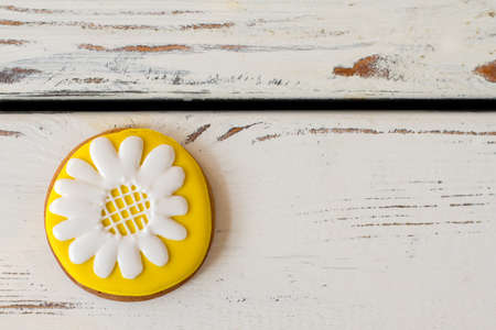 Cookie with picture of flower. Yellow and white icing. Beauty of plain things. Tasty biscuit with...
