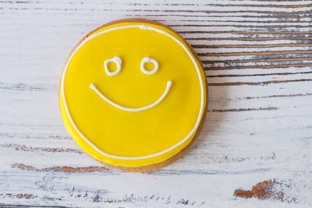 Smiley face cookie. Biscuit with yellow frosting. How to transfer good mood. Dessert that makes you smile.の写真素材
