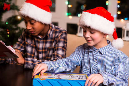 Boys get toys for Christmas. Two boys unpacking Christmas presents. Look what I've got. Got to love Christmas.の写真素材