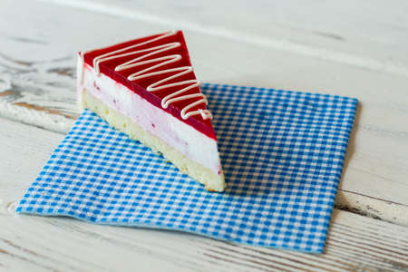 Slice of cake on napkin. Thin layer of jelly. Tasty dessert with currant mousse. Sweet dish in new...