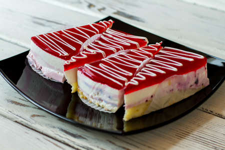 Pieces of cake on plate. Layer of jelly. Dessert with currant mousse. Sweet treat from the shop.の写真素材