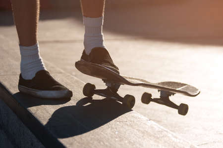 Feet and a skateboard. Legs of standing person. Make another attempt. Progress demands motivation.の写真素材