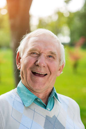 Old man laughing. Portrait of elderly male. Cheerful pages of my memory. Everything is changing so quickly.の写真素材