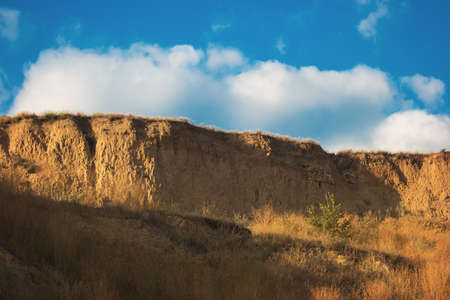 Sandy cliff and sky. High dry grass. Become one with nature. Search for inspiration.の写真素材