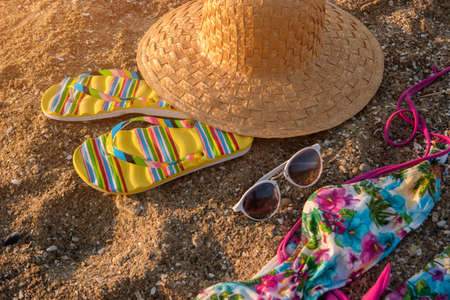 Beach hat and flip flops. Sunglasses lying on sand. Leave problems and bustle behind. Warm tropical resort.の写真素材