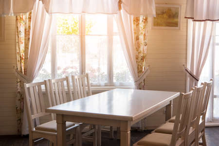 Table and chairs in house. Sunshine in the room. Invite friends to your home. Simple and cozy.