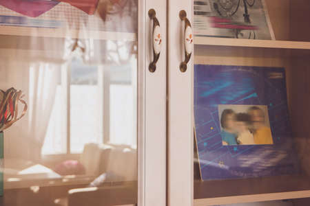 Glass doors of a cupboard. Covers with illustrations. Collection of rare vinyl records. Hits of bygone era.の写真素材
