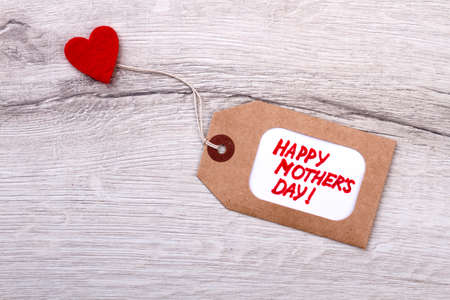Happy Mother`s Day tag. Tag and heart on wood. Handmade greeting label. Present love on Mother`s Day.の写真素材