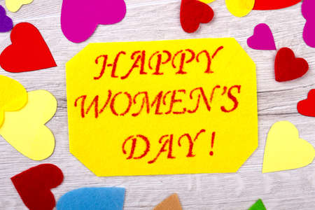 Women`s Day card and hearts. Fabric hearts near yellow postcard. Colors of joy. Prepare surprise for...