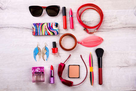 Phone, sunglasses and cosmetics. Bow hair band and earrings. Complete your style with accessories. Items of modern fashionable look.の写真素材