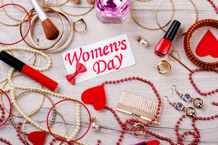 Women`s Day card with jewelry. Make-up products near hearts. Stylish and expensive look. Getting...