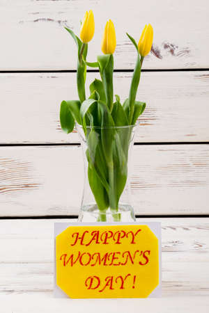 Women`s Day card and tulips. Flowers in vase near card. Make nice surprise for wife. Handmade spring...