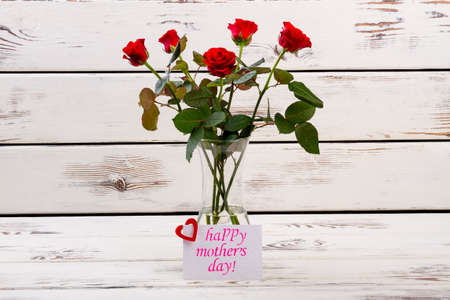 Roses and card for mother. Paper with heart near flowers. Write congratulation for mom. Classical gift set.の写真素材