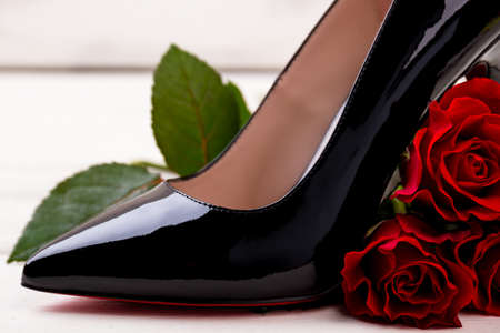 High heel footwear and rose. Red flower and shoe. Romantic present for lady.の写真素材