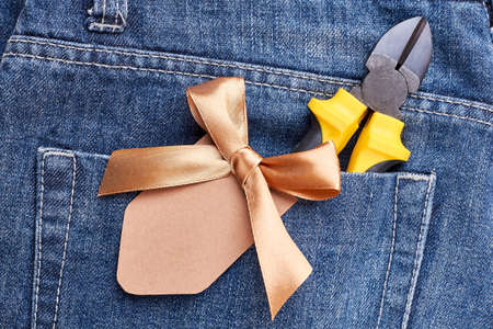 Jeans poket with pliers. Ribbon bow on pants pocket. Make a present for father.の写真素材