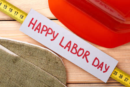 Hard hat and tape measure. Happy Labor Day paper. Congratulate your friends.