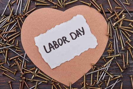 Labor Day card and screws. Heart-shaped paper near iron nails. Learn to repair your house.の写真素材
