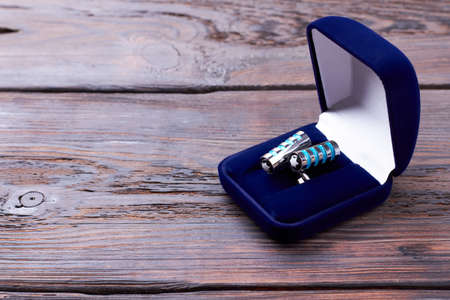 Cufflinks in velvet blue box. Case with cufflinks on wood. Formal stylish look accessory.の写真素材