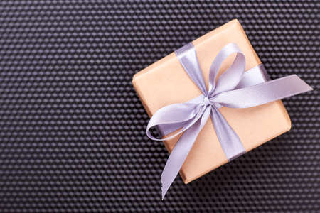 Gift box on black background. Present box and wisteria bow. Art of wrapping presents.の写真素材