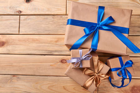 Gift boxes on wooden background. Colorful ribbon bows on presents. Holiday spirit and atmosphere.の写真素材