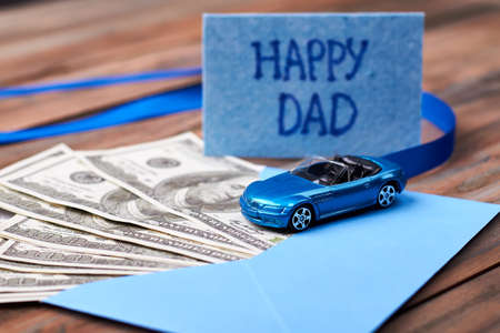 Happy Dad's card and car. Ribbon and envelope with money. Valuable gift for dad.の写真素材